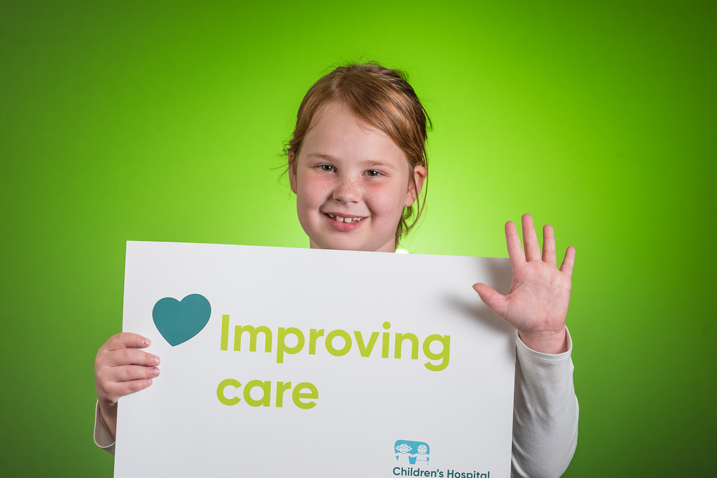 smiling child holding sign