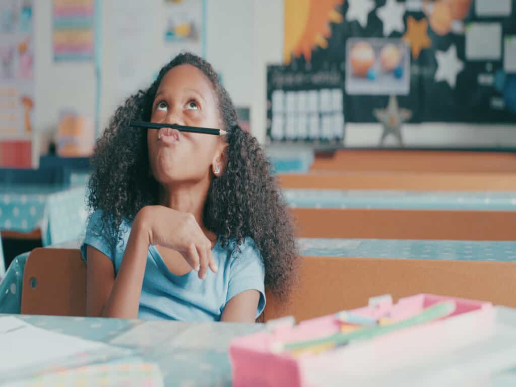 smiling young girl with pencil on face