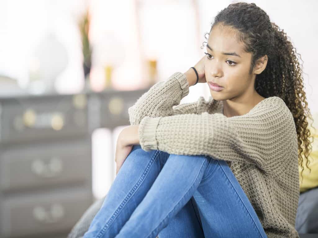 sad teen girl with hand on head