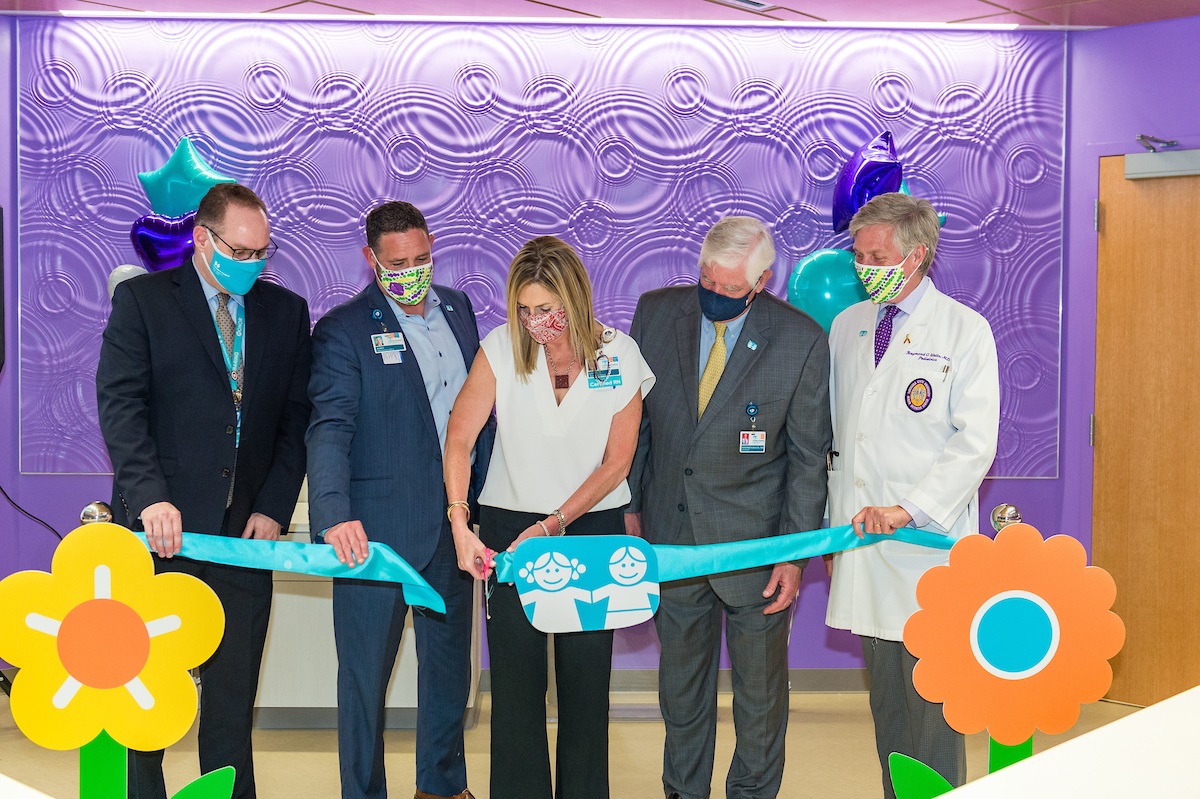 woman cutting ribbon for a ceremony 