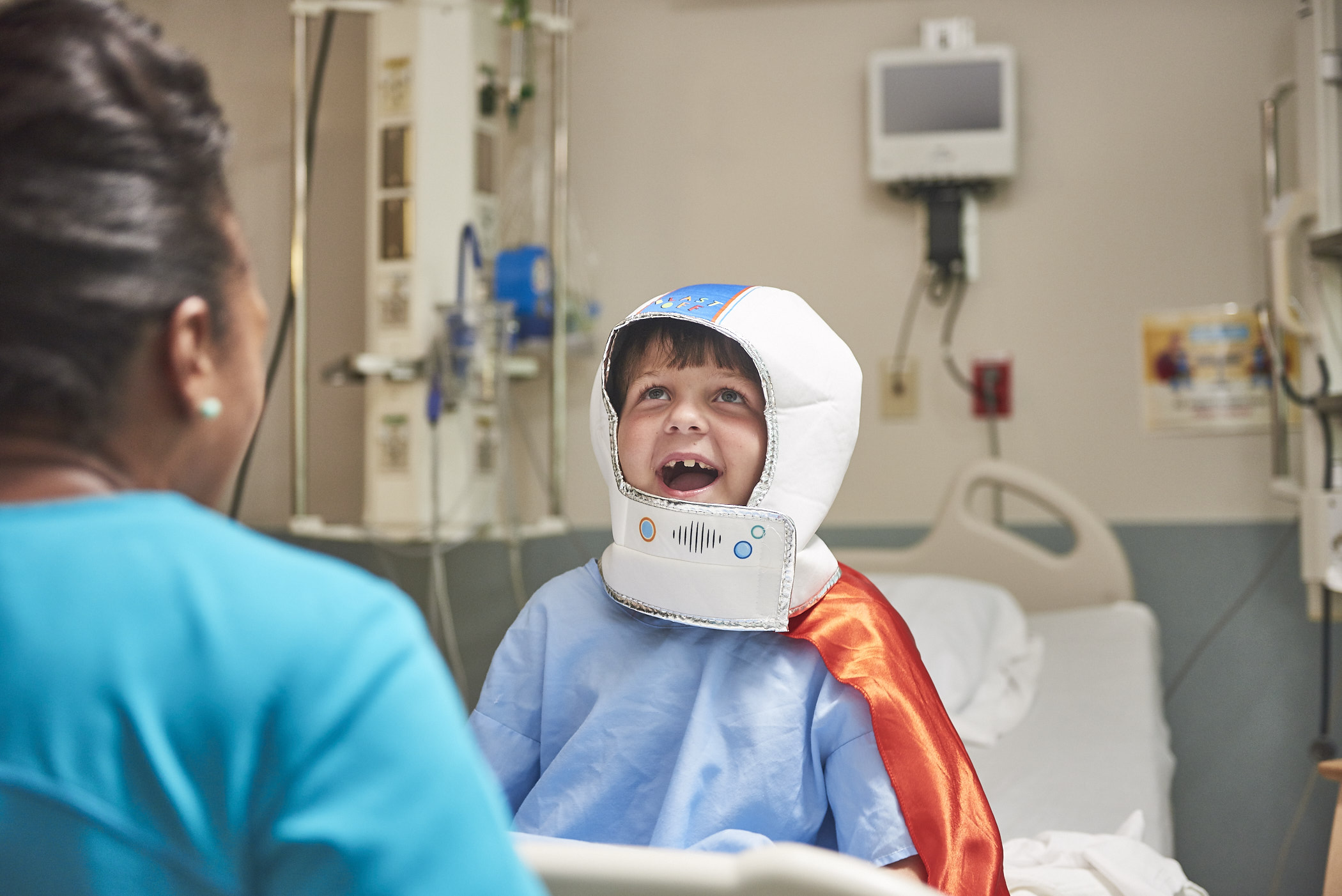 toddler smiling with astronaut helmet costume