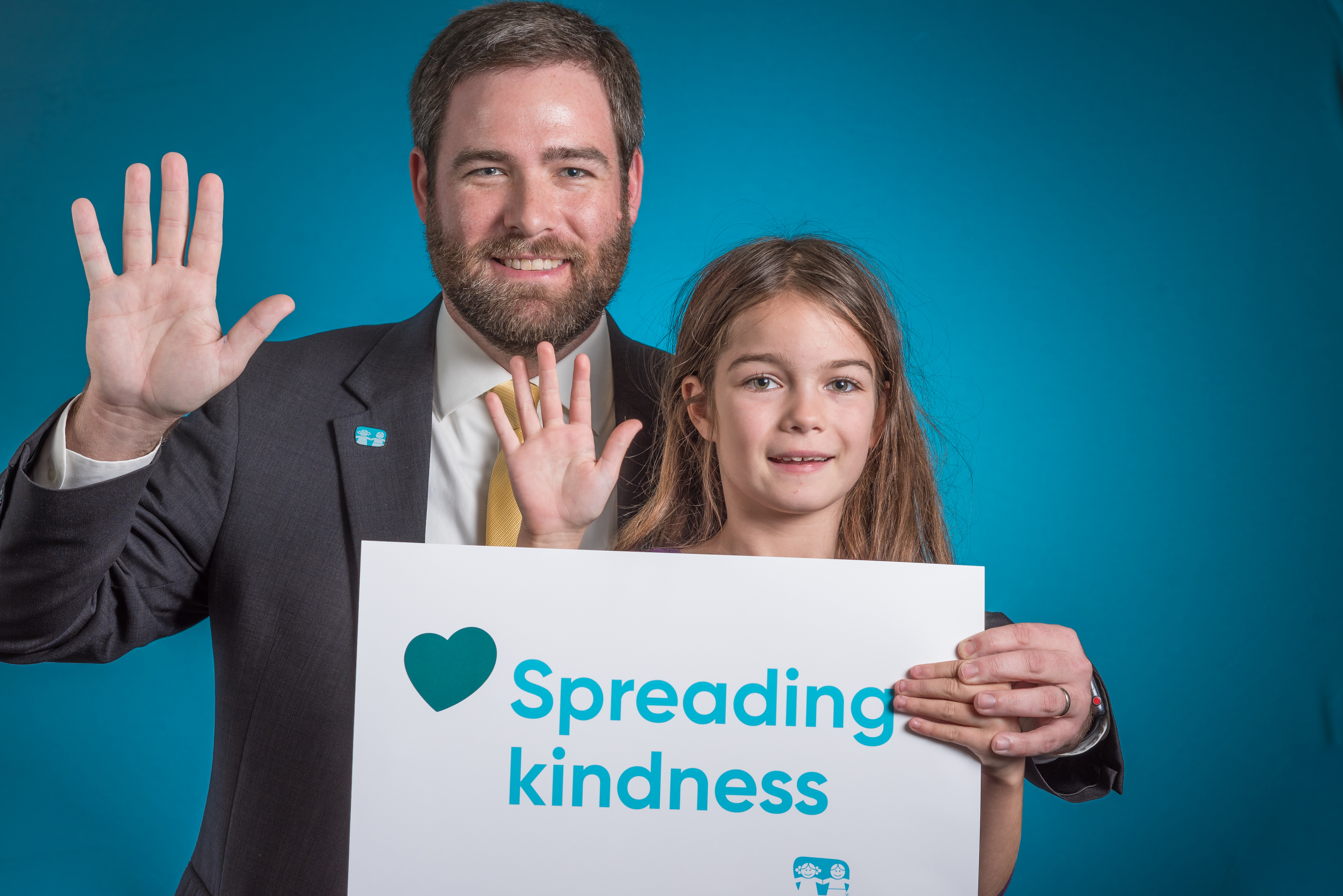 child and doctor posing with sign