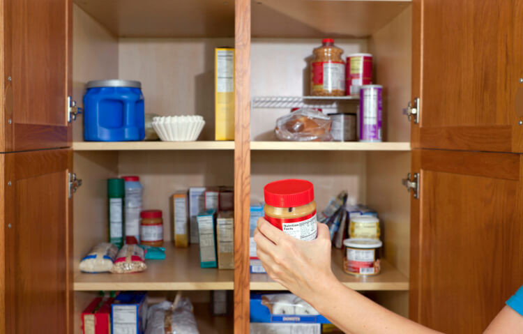 someone grabbing a jar of peanut butter 