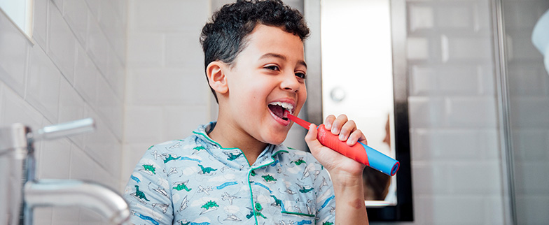 Child brushing teeth in the morning.